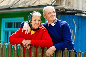 Closeup portrait happy, senior, elderly, old couple, grandmother, grandfather, pensioners on porch of country house, waiting, looking for kids